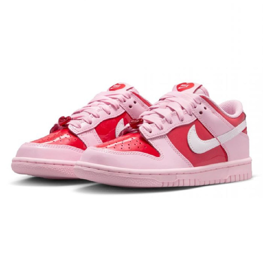 Pink and red kids low-top sneakers with lace-up ties and white swoosh on the sides.