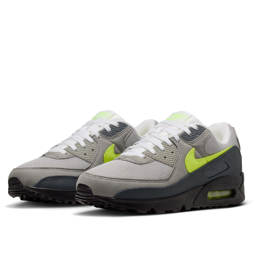 Pair of gray low-top sneakers with white laces, neon yellow accents, and black sole