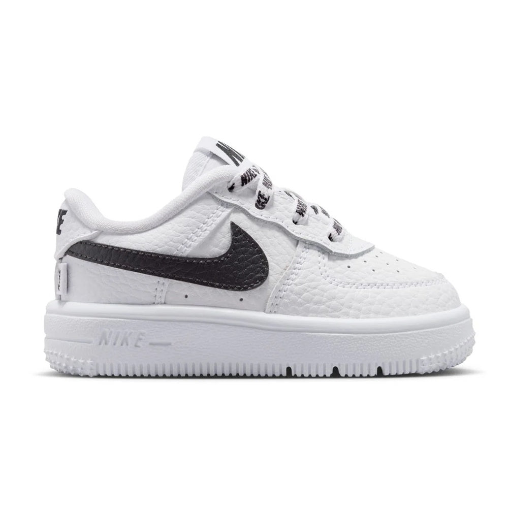 White and black toddler low-top sneakers with Nike swoosh and lace-up front