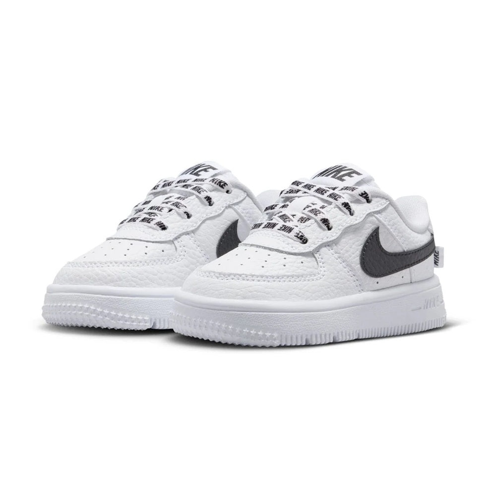 Pair of white toddler low-top sneakers with Nike swoosh and lace-up closure