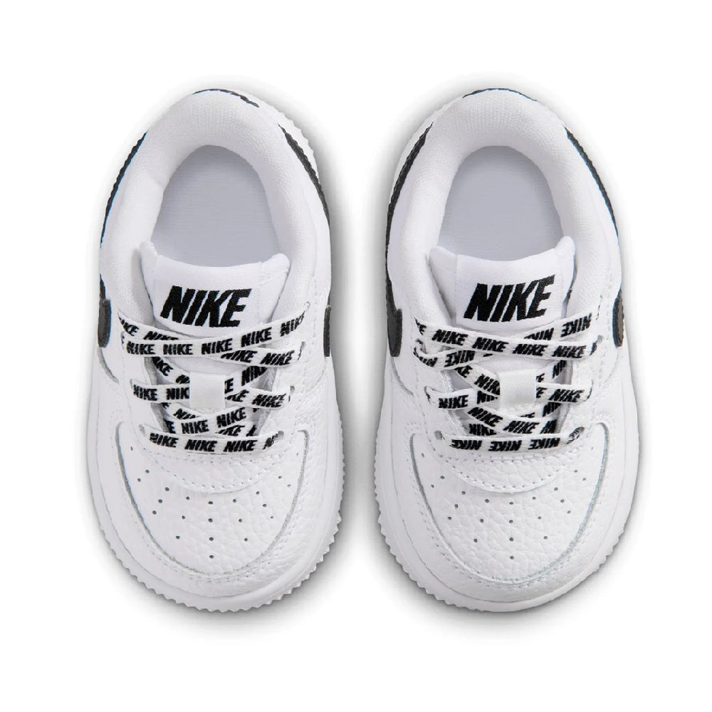 White toddler sneakers showing NIKE text lining at the heel and collar