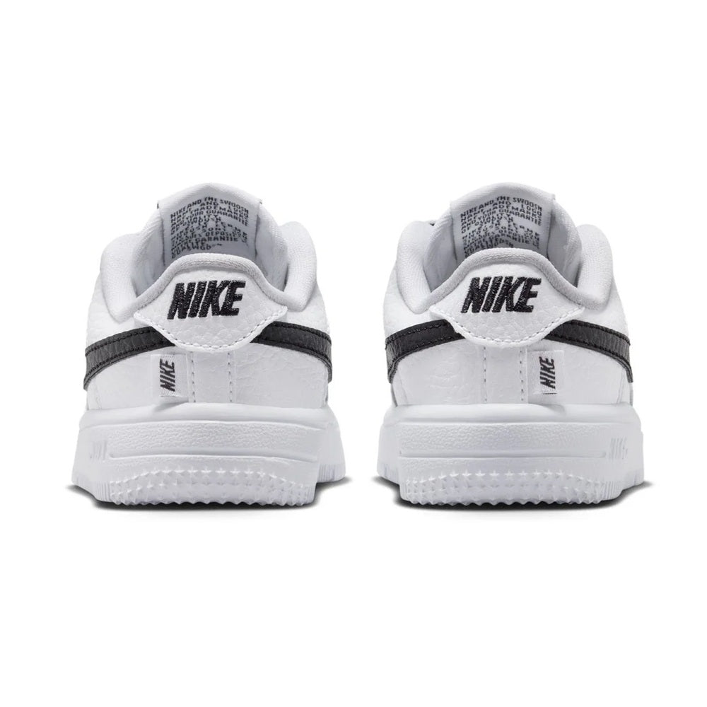 Back view of white toddler low-top sneakers with Nike heel tab and black trim