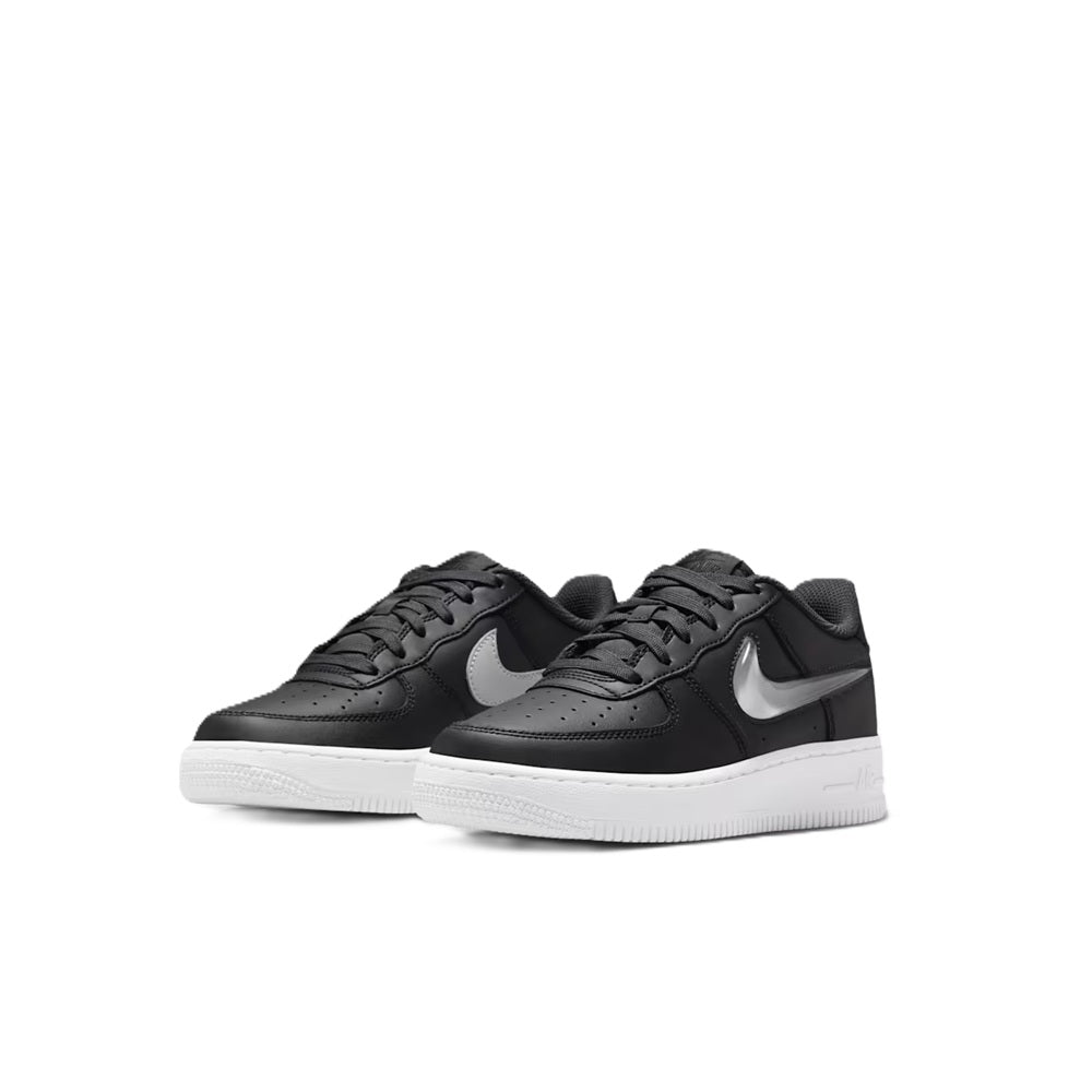 Pair of Nike Air Force 1 kids sneakers in black with white swooshes and midsoles