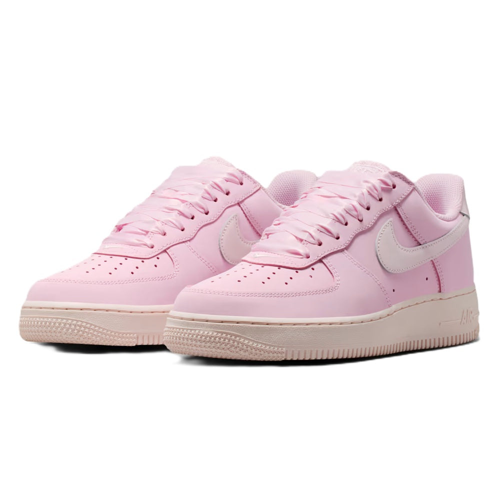 Pair of pink low-top sneakers with swoosh overlays and lace-up uppers