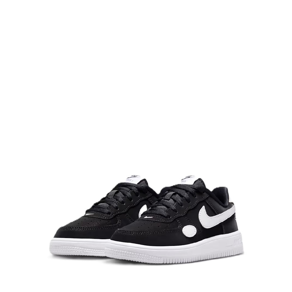 Pair of black kids low-top sneakers with white Swoosh and lace-up closure