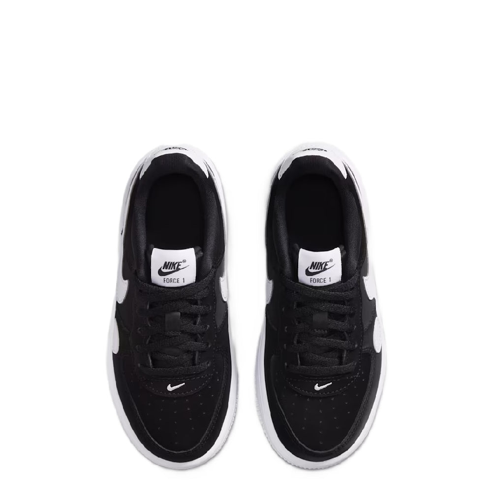 Black kids low-top sneakers with white trim and Nike branding on tongue