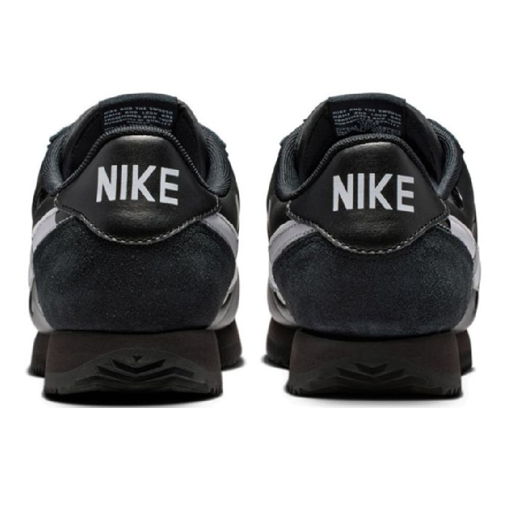 Women's Nike Cortez sneakers, black back view with NIKE heel logo and suede panel