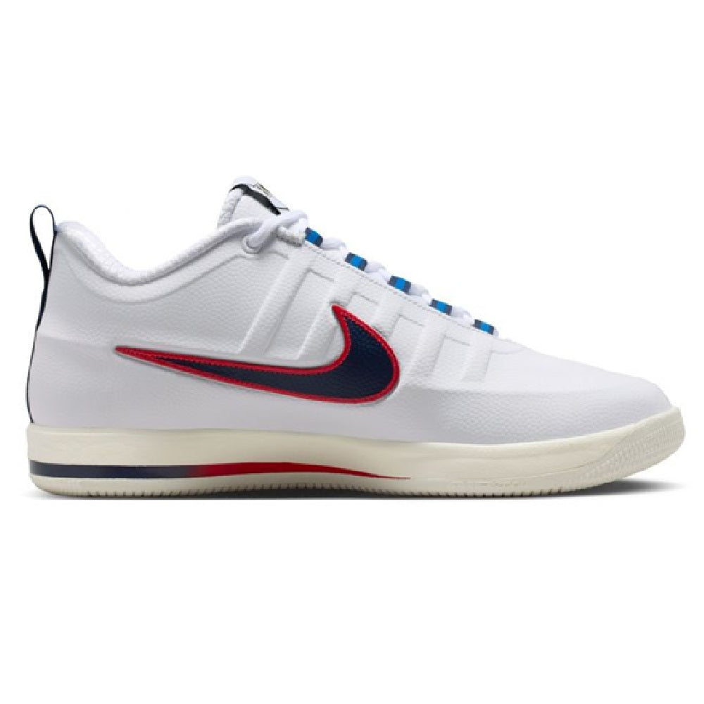 White low-top sneaker side view with navy/red swoosh, blue lace accents, cream outsole