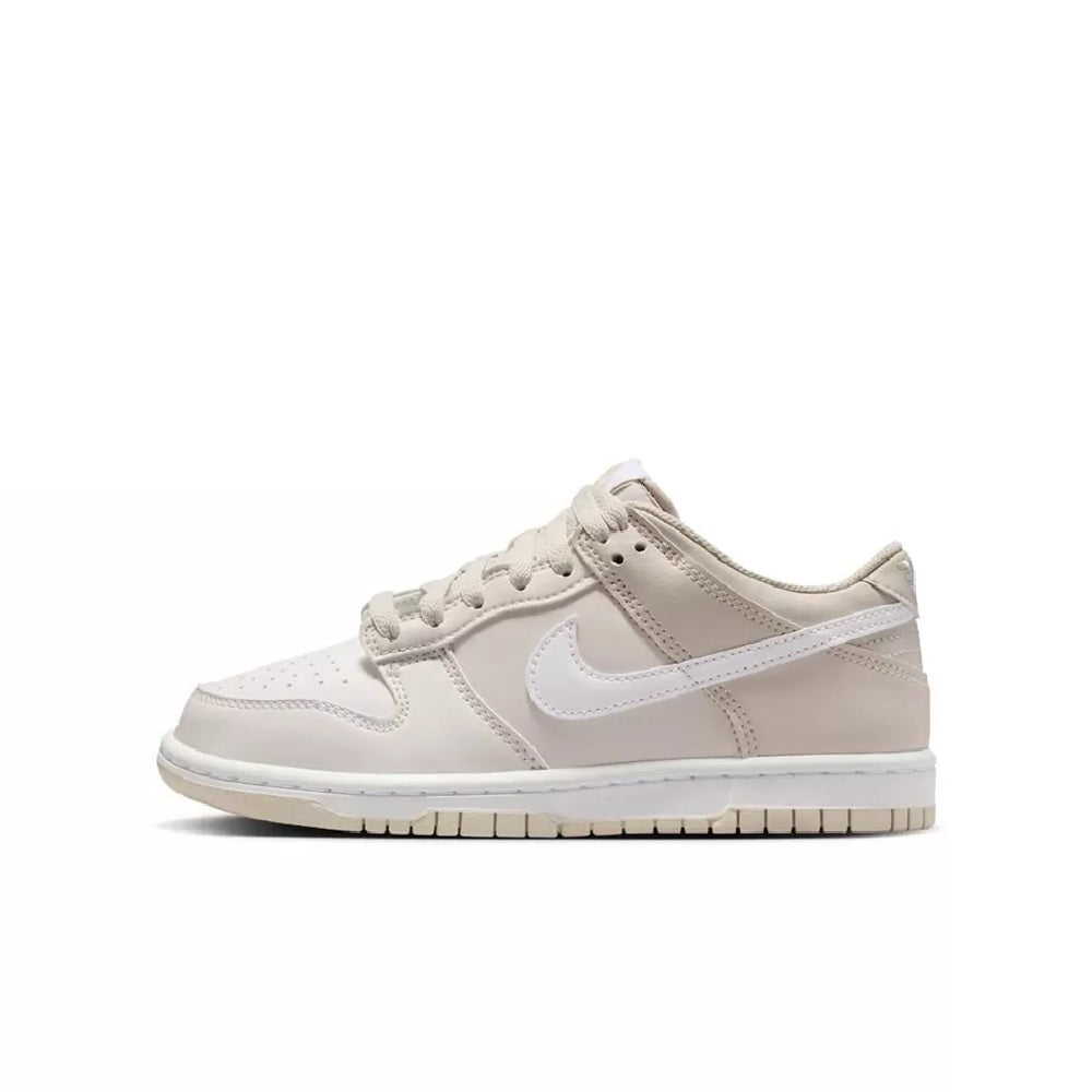 Kids' low-top sneaker side view with white base, light beige swoosh, padded collar
