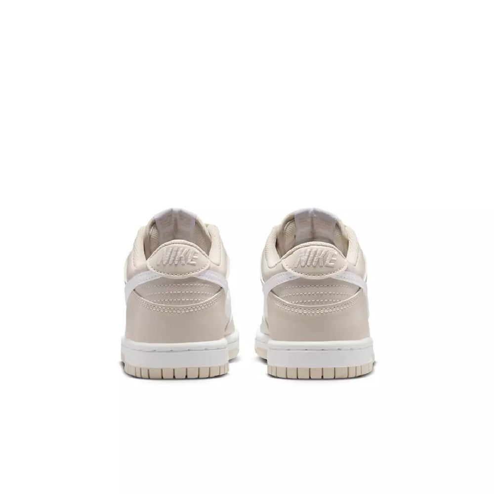 Kids' low-top sneaker back view with Nike heel tab, white and light beige panels