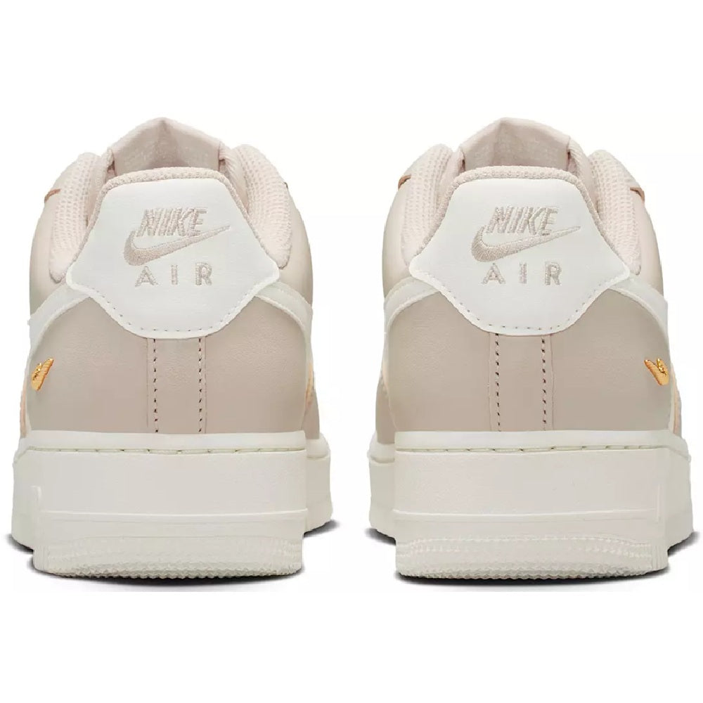 Nike Air Force 1 low sneakers, cream heel with 'AIR' branding, lace-up, gold tag