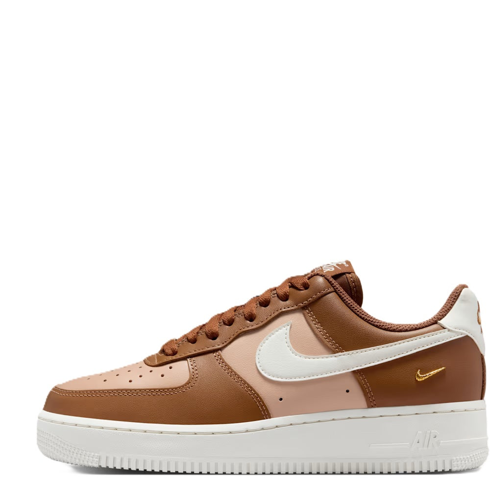 Tan low-top sneaker side view with white Swoosh, brown laces, and gold heel detail