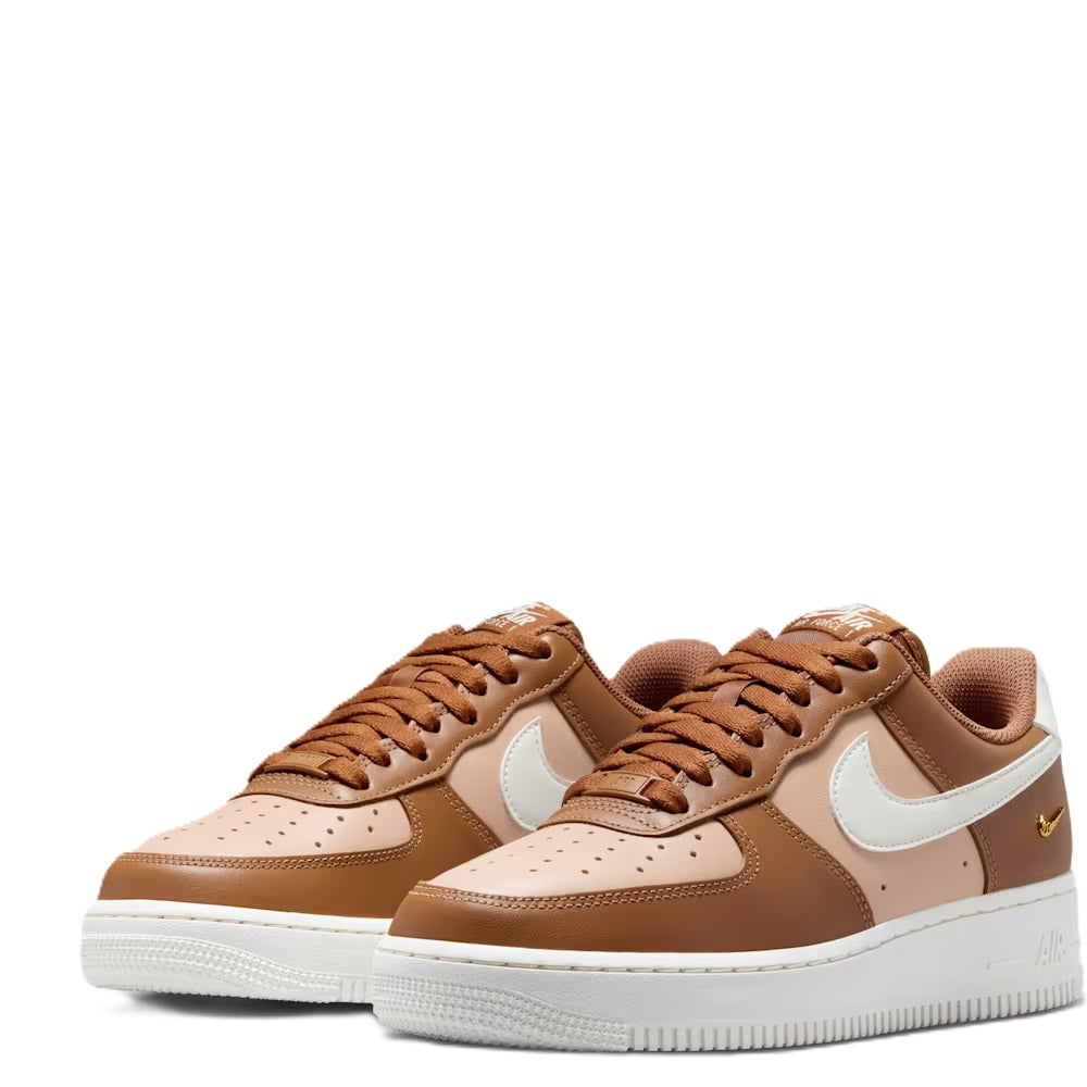 Pair of tan low-top sneakers with white Swoosh, brown laces, and thick white sole