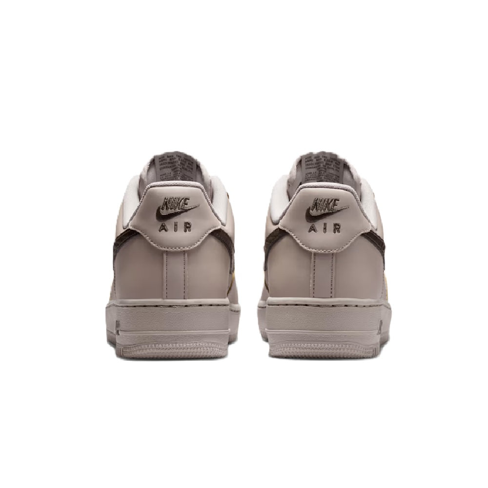 Nike Air Force 1 low-top sneakers with rear Air-branded heel tabs and light gray uppers