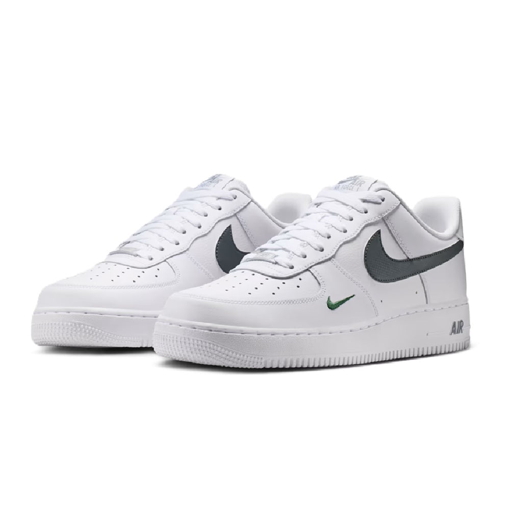 Nike Air Force 1 sneakers, white with dark gray swoosh and green logo, lace-up.