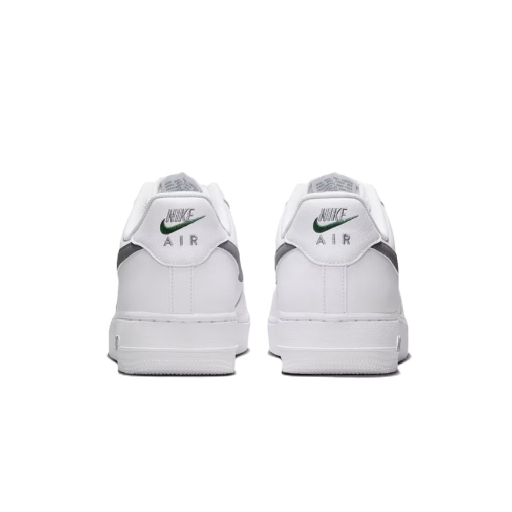 Nike Air Force 1 sneakers, back view with white heel tabs and green Nike Air logo.