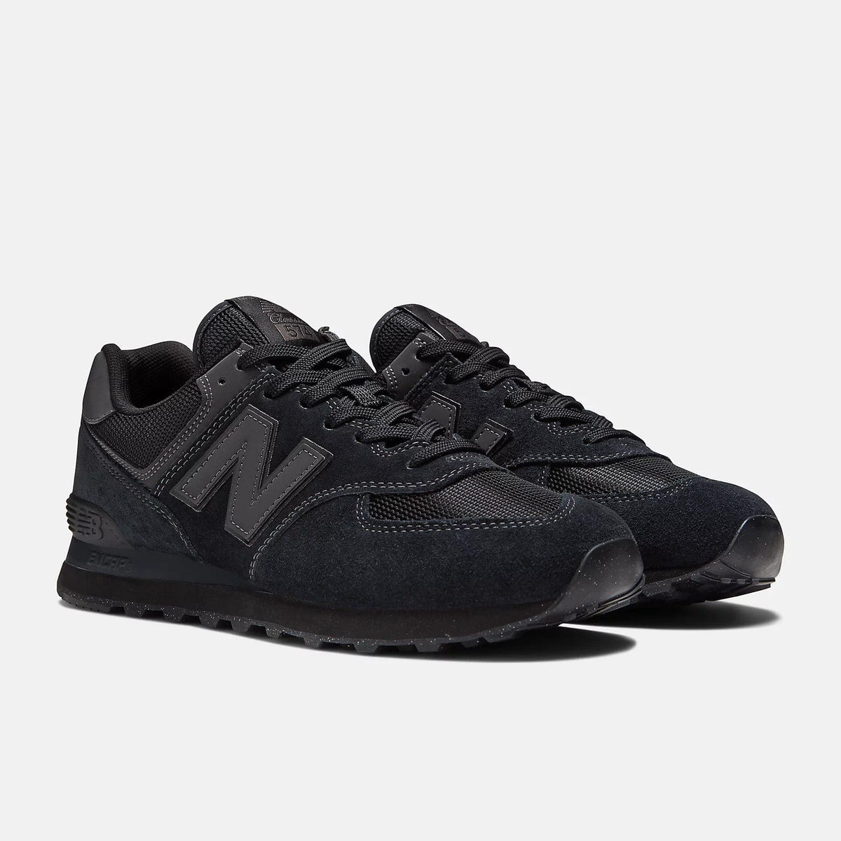 Black pair of lace-up sneakers with N logo, mesh and suede textures, and tread sole