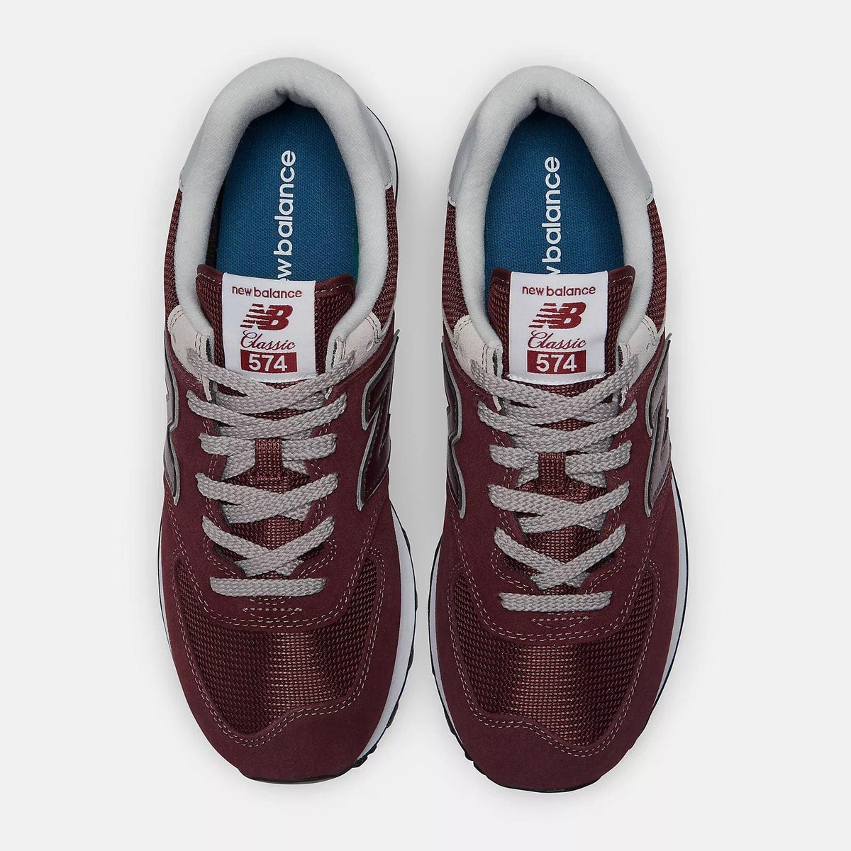 Burgundy sneakers top view with white laces and 574 label on tongue