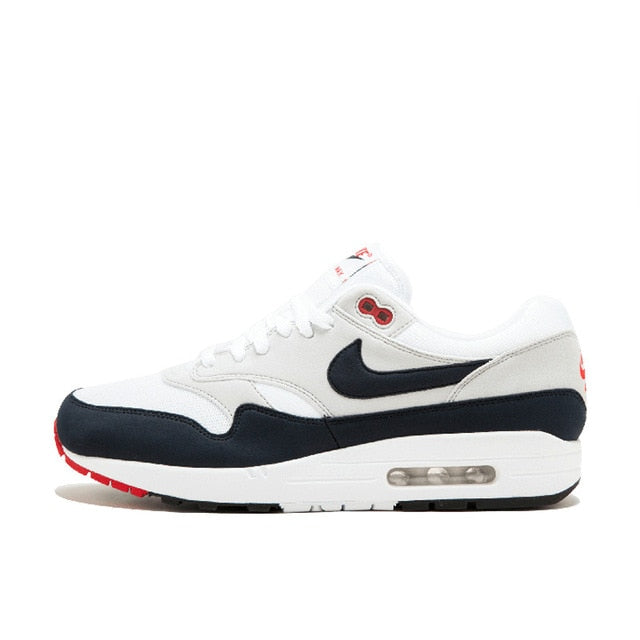 Nike Air Max 1 running shoe, white with navy swoosh and red heel accent