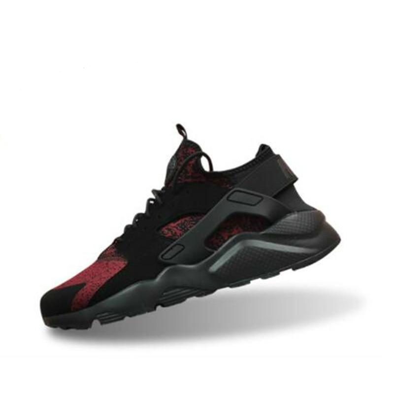 Black running shoes with red accents, dark gray midsole, hook-and-loop strap