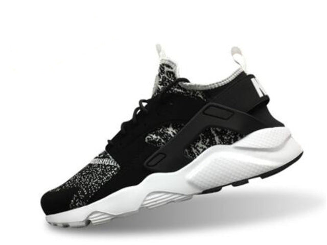 Black running shoes with speckled accents and white sole, hook-and-loop strap