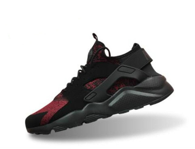 Black running shoes with red speckle side panel, dark gray sole, hook-and-loop strap